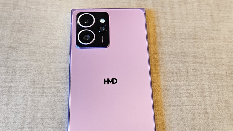 HMD Skyline on a light wooden table with its back and cameras showing in neon pink.