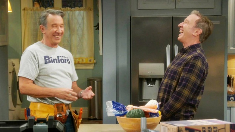 Tim Taylor and Mike Baxter laughing in a kitchen.