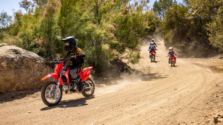 Young person riding a Honda CRF110F on a desert trail