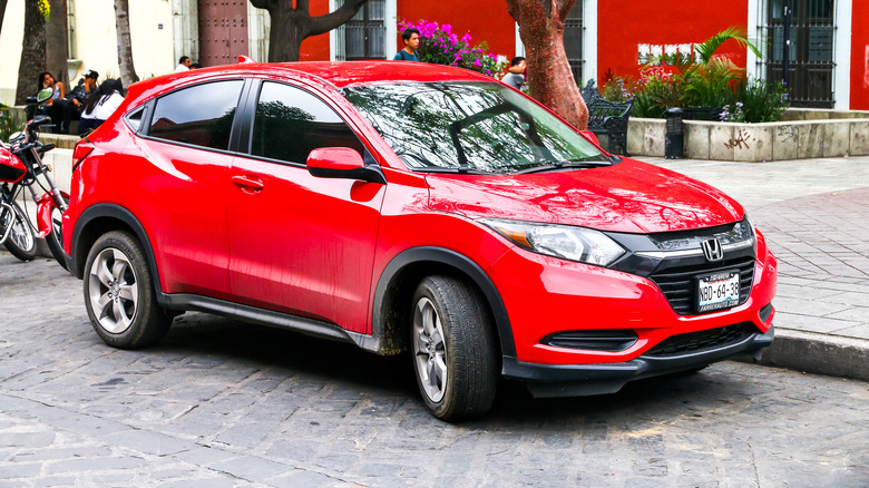 A red Honda HR-V on a city street