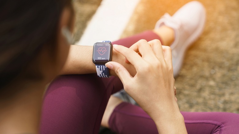 Woman wearing Apple Watch using heart rate sensor