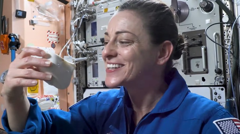 woman drinking coffee with cup in space ship