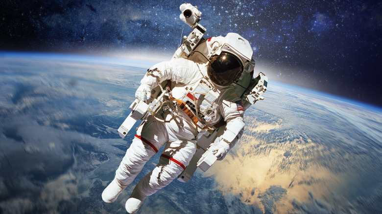 astronaut floating in outer space with earth backdrop