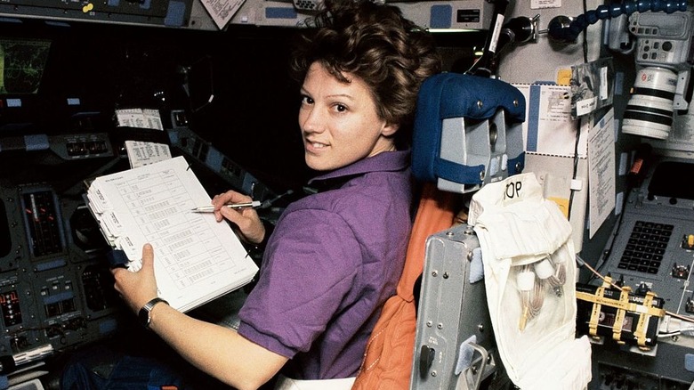 astronaut eileen collins using a pen in space