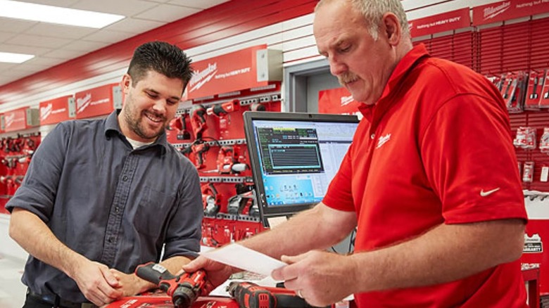 A Milwaukee Tool technician returning a repaired power tool to a customer