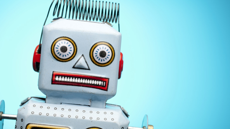 Close up picture of a retro tin robot toy. The toy's expression is startled.