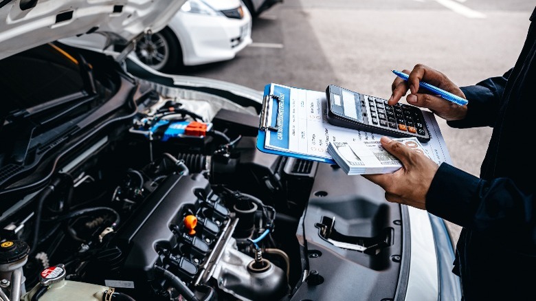 a mechanic with a calculator