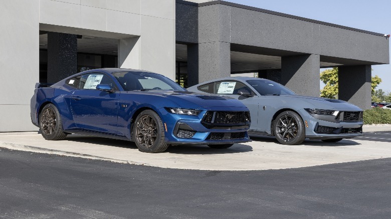 Ford mustangs parked outside a garage