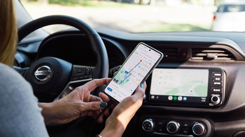 A woman using a navigation app in her car.