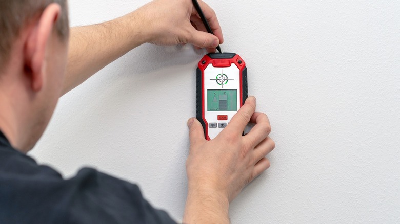 Man using stud finder on a wall