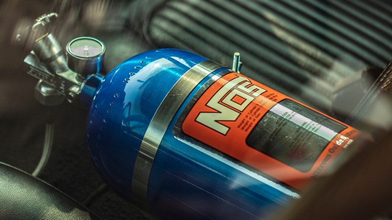 A blue NOS bottle in a car