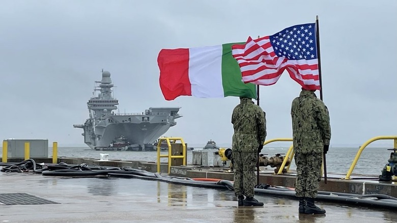 American and Italian sailors holding respective flags with Cavour in the background