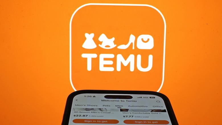 Temu logo behind a phone