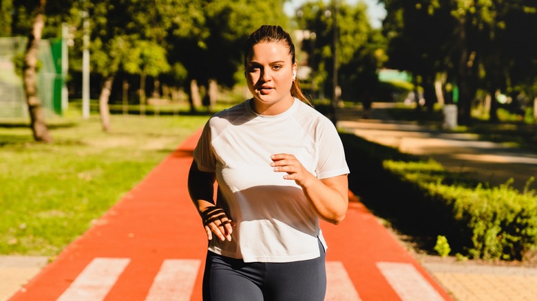 woman jogging down a path