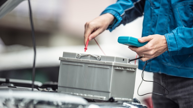 Person checking battery of electric car