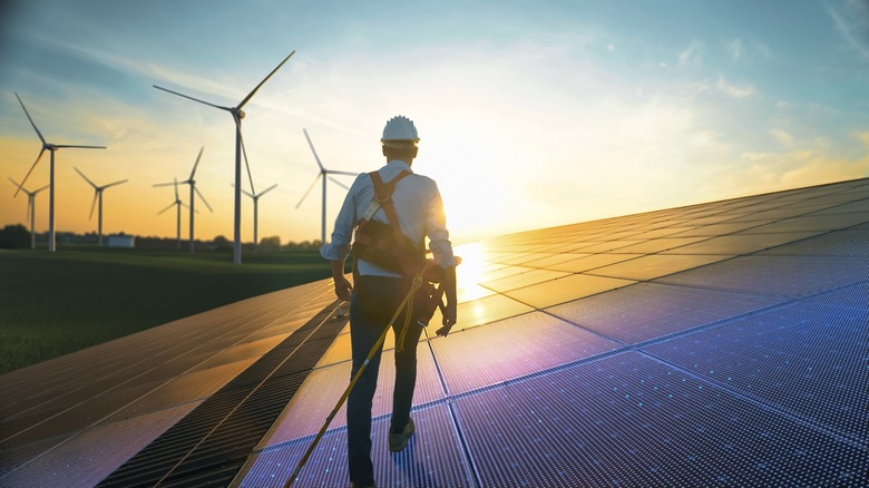 worker walking on solar panel grid