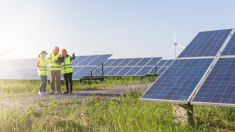 workers examining solar panels