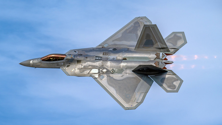 The F-22 Raptor flying over blue and cloudy skies