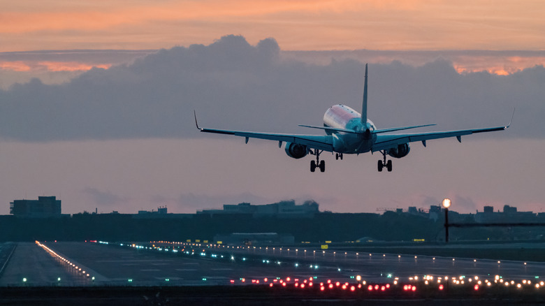 Airplane landing at sunrise.