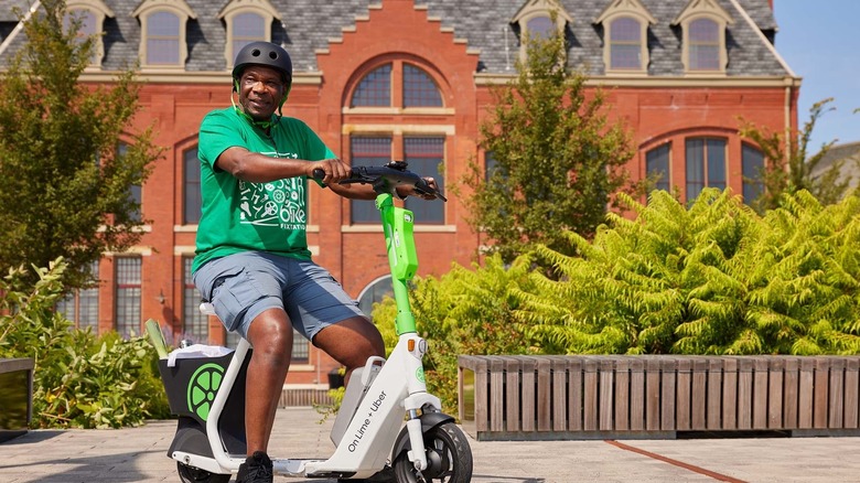 A man rides a seated Lime scooter.