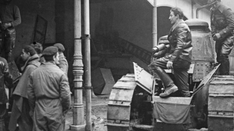 black and white image of men standing around a Renault FT