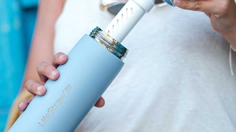 woman holding LifeStraw Go Bottle revealing filter