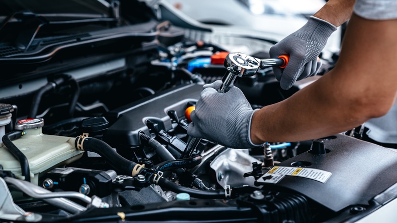 Person working on car engine