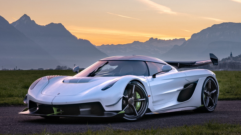 white Koenigsegg Jesko parked on asphalt in front of mountain ridge