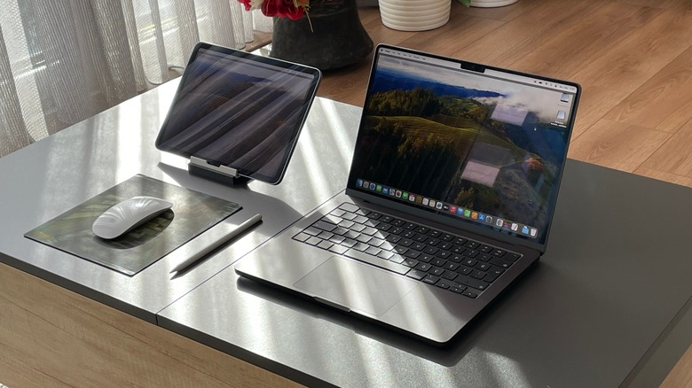 MacBook Pro next to iPad, Magic Mouse, and Apple Pencil