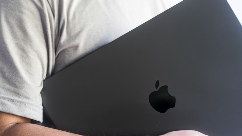 man holding MacBook Pro