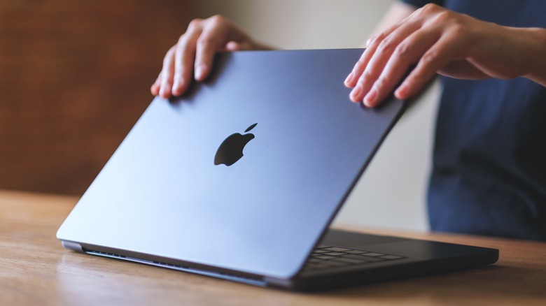 person opening a MacBook Pro