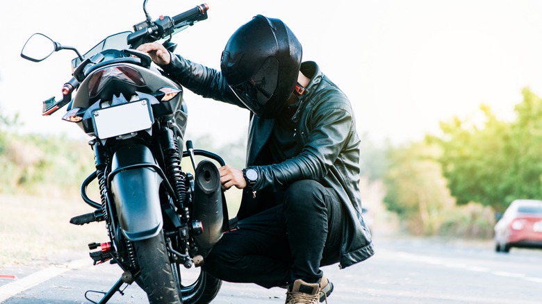 Rider repairing motorcycle