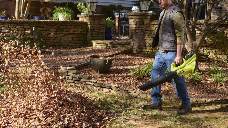 Man using Ryobi blower on leaves