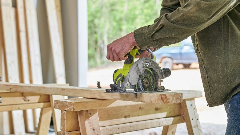 Man cutting a piece of wood with a circular saw