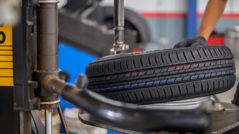 A mechanic putting a new tire on a car wheel