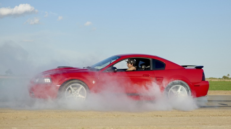 A person doing a burnout (spinning their tires while remaining stationary)