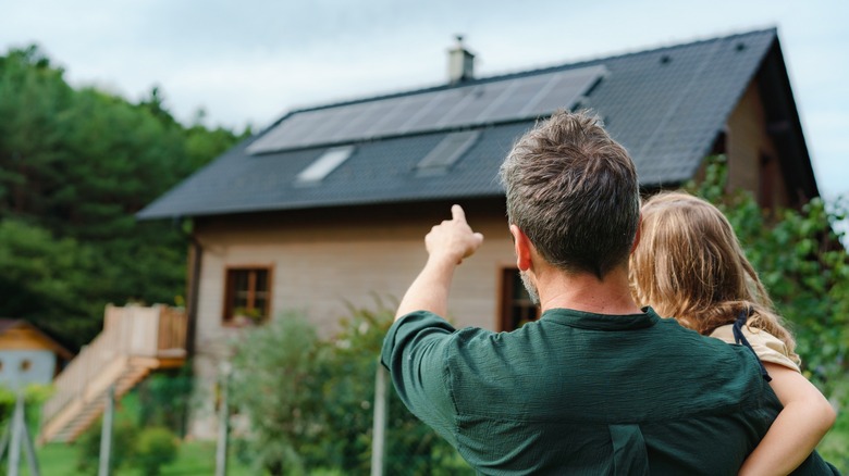 man pointing toward solar panels