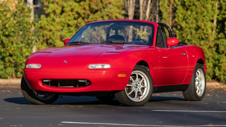 A Red Miata without a front license plate