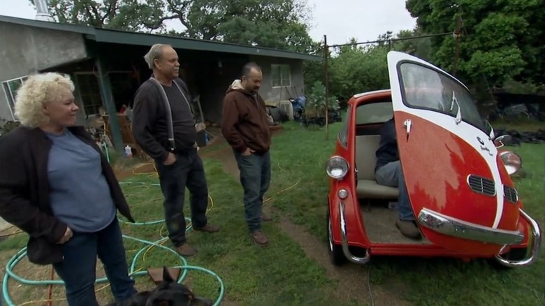 Mike Wolfe of American Pickers climbing into a red and white BWM Isetta 300 they purchased