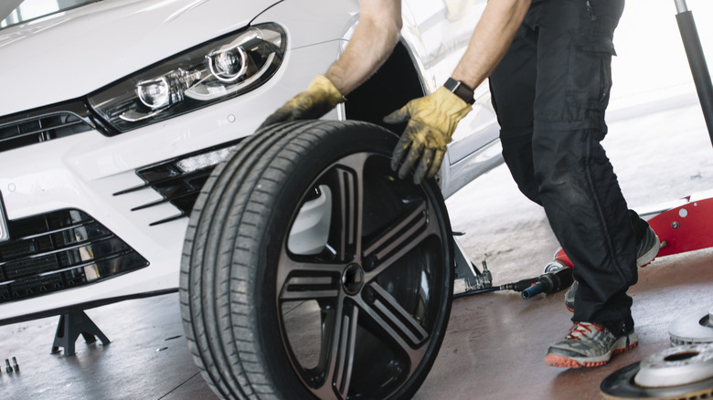 mechanic holding replacement tire