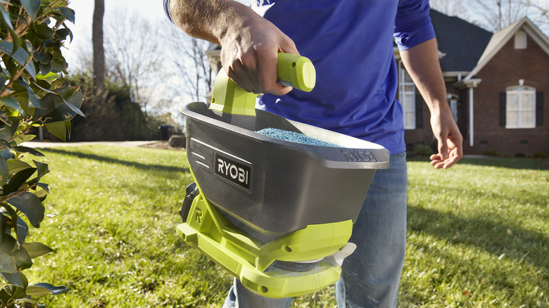 Person using power spreader in their lawn