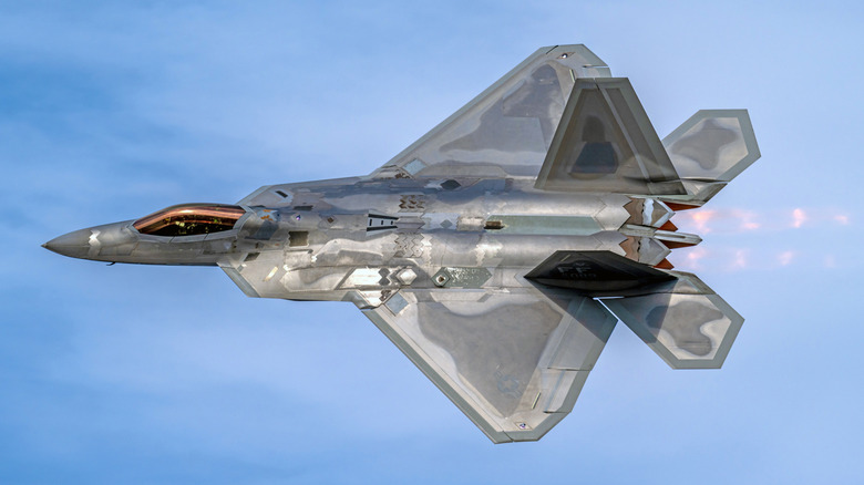 The US Air Force 2023 F-22 Raptor Demo Team jet makes a high-speed past with the afterburners fully lit, while doing an evening performance at the EAA Air Venture event in Oshkosh, WI.