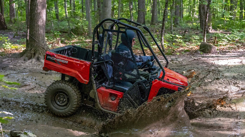 Side view of a Rider driving the Pioneer 520 into the mud