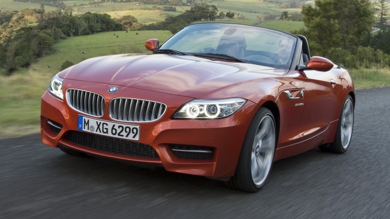 2013 BMW Z4 driving on a road with rolling hills and trees in the background