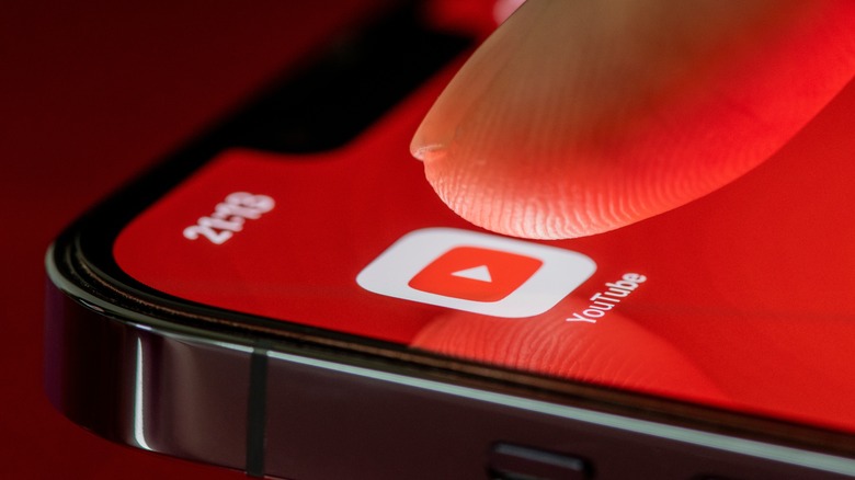 Finger touching the YouTube app on a smartphone 