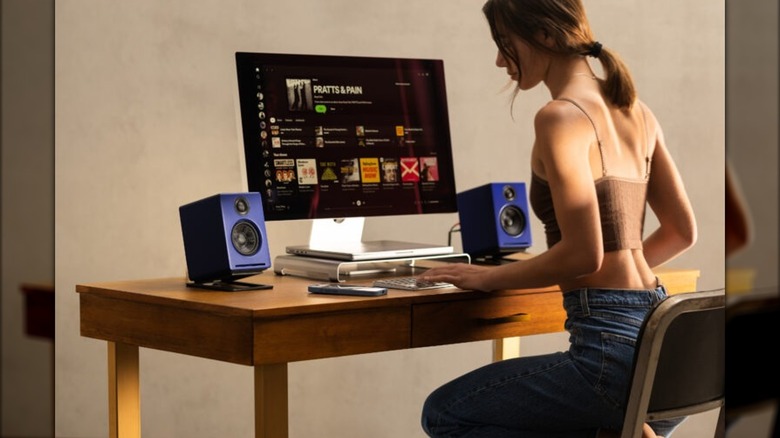 A Woman At A PC Desk With A2+ Speakers In Blue