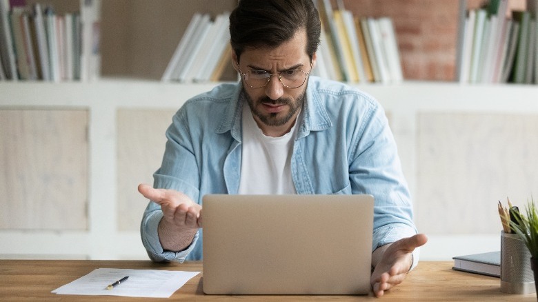 Man annoyed at slow laptop