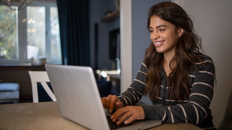 Woman using a laptop with happiness