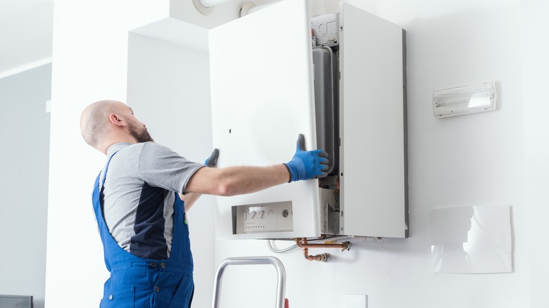 man installing hybrid water heater