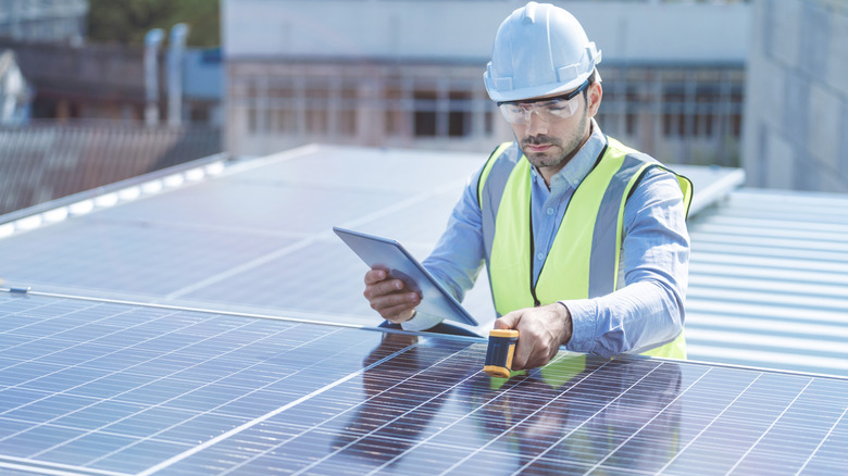 An engineer checking a solar panel.